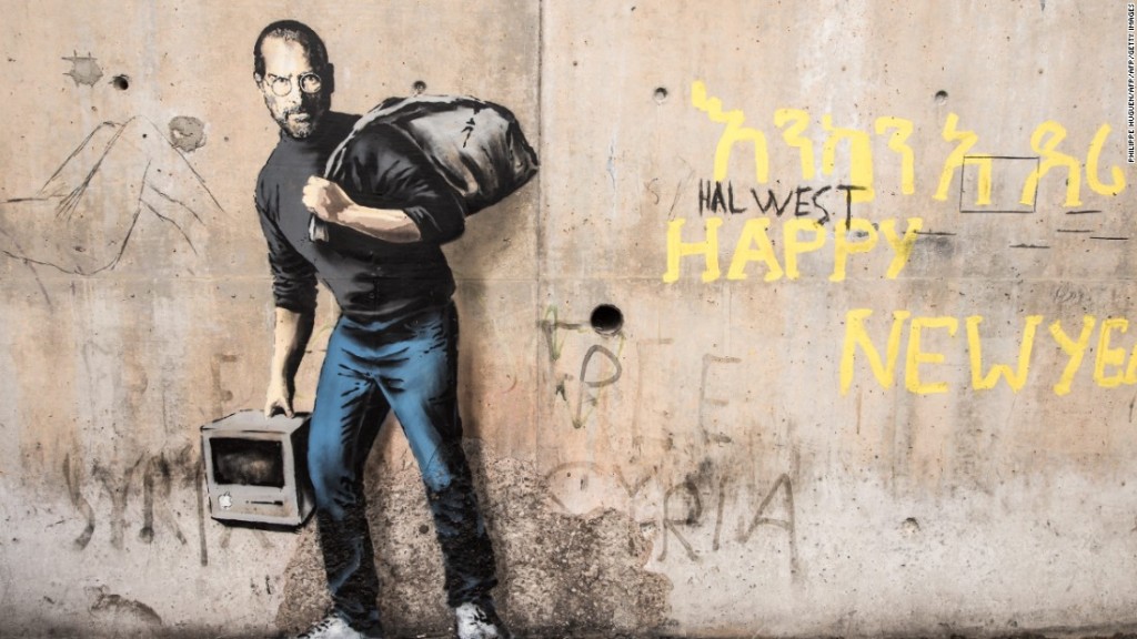 In December Banksy created this image of Steve Jobs, the son of Syrian refugees, in Calais' migrant camp (CNN.)