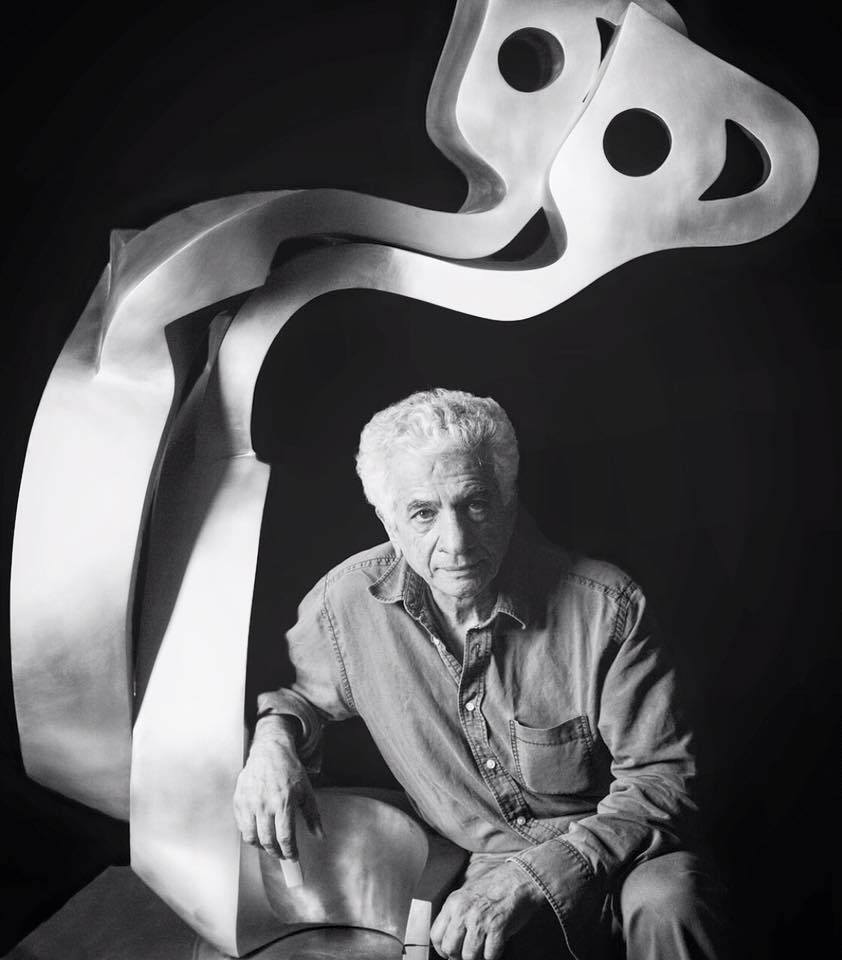 Iranian sculptor, collector, and historian Parviz Tanavoli poses in front of his work (Facebook).